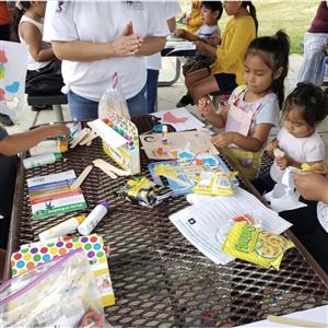 Children do crafts at a picnic table